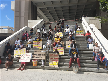 全境封锁的消息宣布之后，40名开普敦Khayelitsha棚户区居民在市政厅台阶上以一米的距离抗议，要求政府在封禁措施前提供饮用水。图片来源：Mary-Anne Gontsana